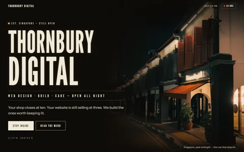 Thornbury Digital v7: the wordmark THORNBURY DIGITAL in cream signage capitals set in the dark beside a Singapore shophouse row at night, one doorway glowing gold.