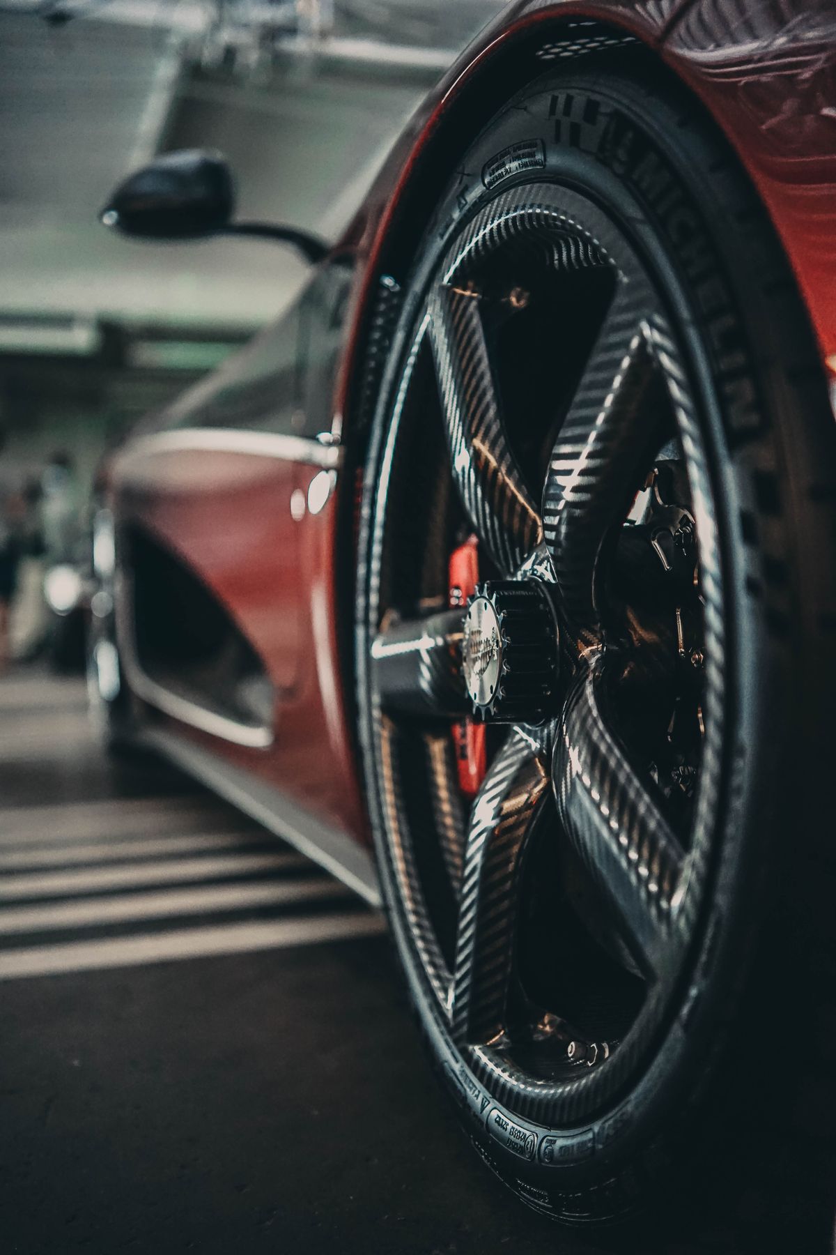 A forged wheel and carbon-ceramic disc on a red Kestrel, low afternoon light.