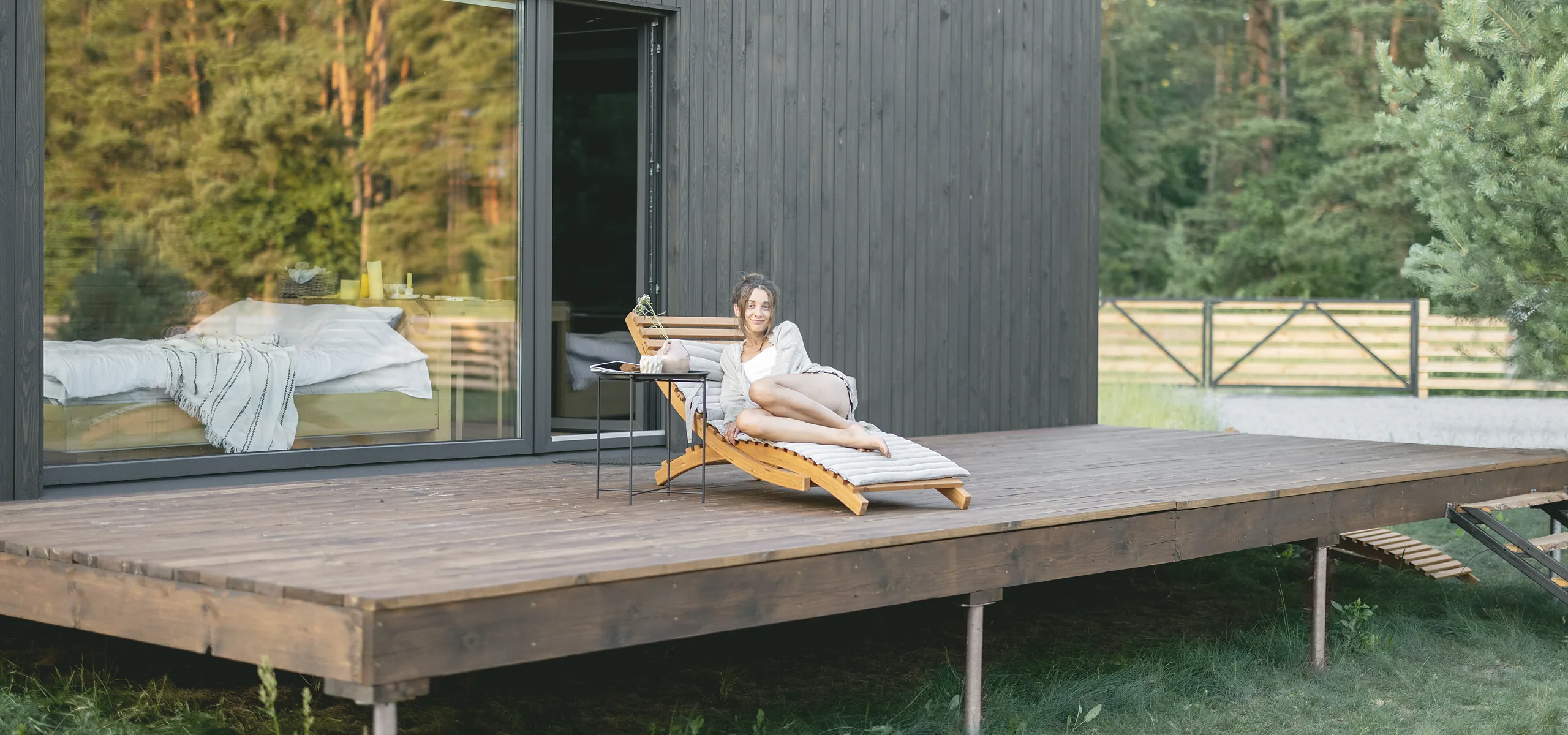 The Pine lodge in charred larch, its glass wall slid open onto a long deck