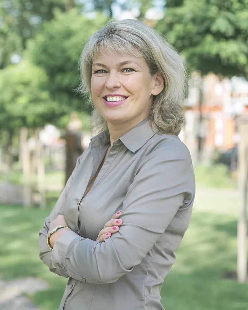 Fiona Kerr, sales director, in a grey shirt with her arms folded, birch trees behind her