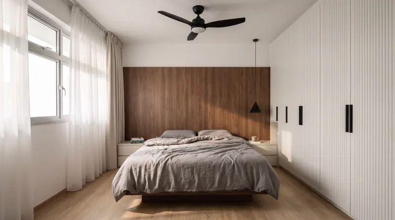 After: the master bedroom with a platform bed against a walnut headboard wall, a fluted white wardrobe and sheer curtains.