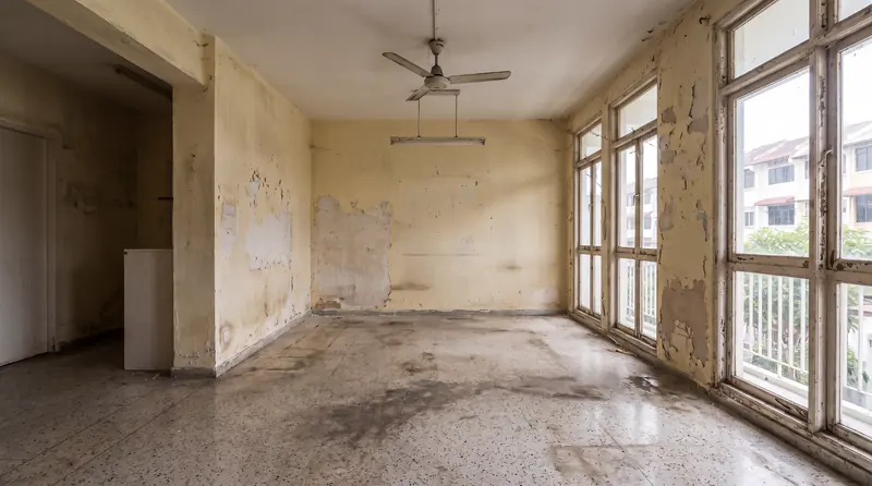 Before: the same room with stained terrazzo, peeling paint and bare timber windows.