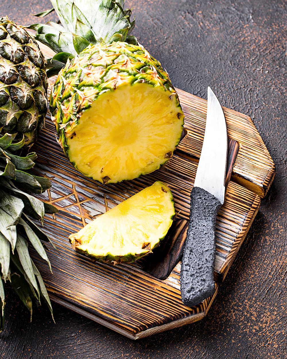 A pineapple sliced into rings on a wooden cutting board