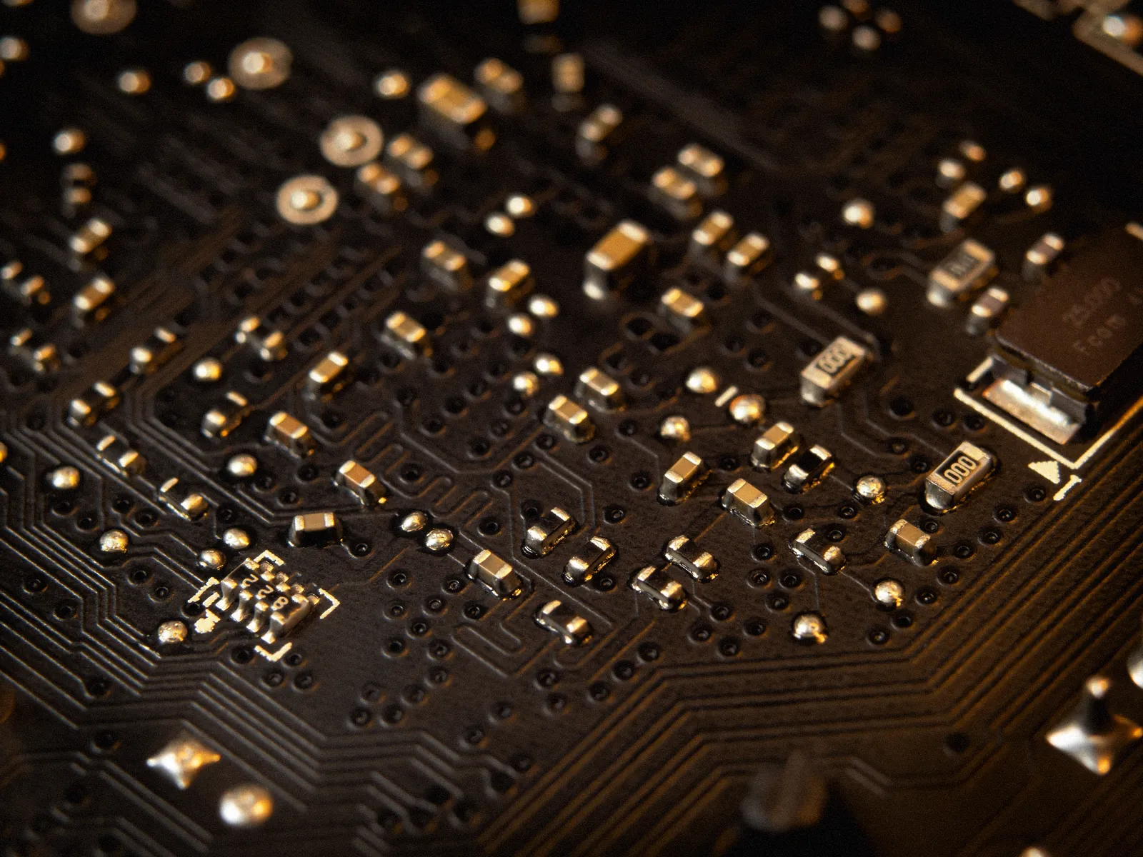 Gold contacts and components on a dark board, close up.