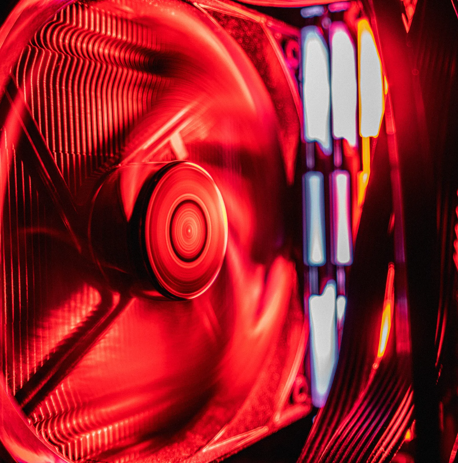 An intake fan lit red, close up, its blades a blur.
