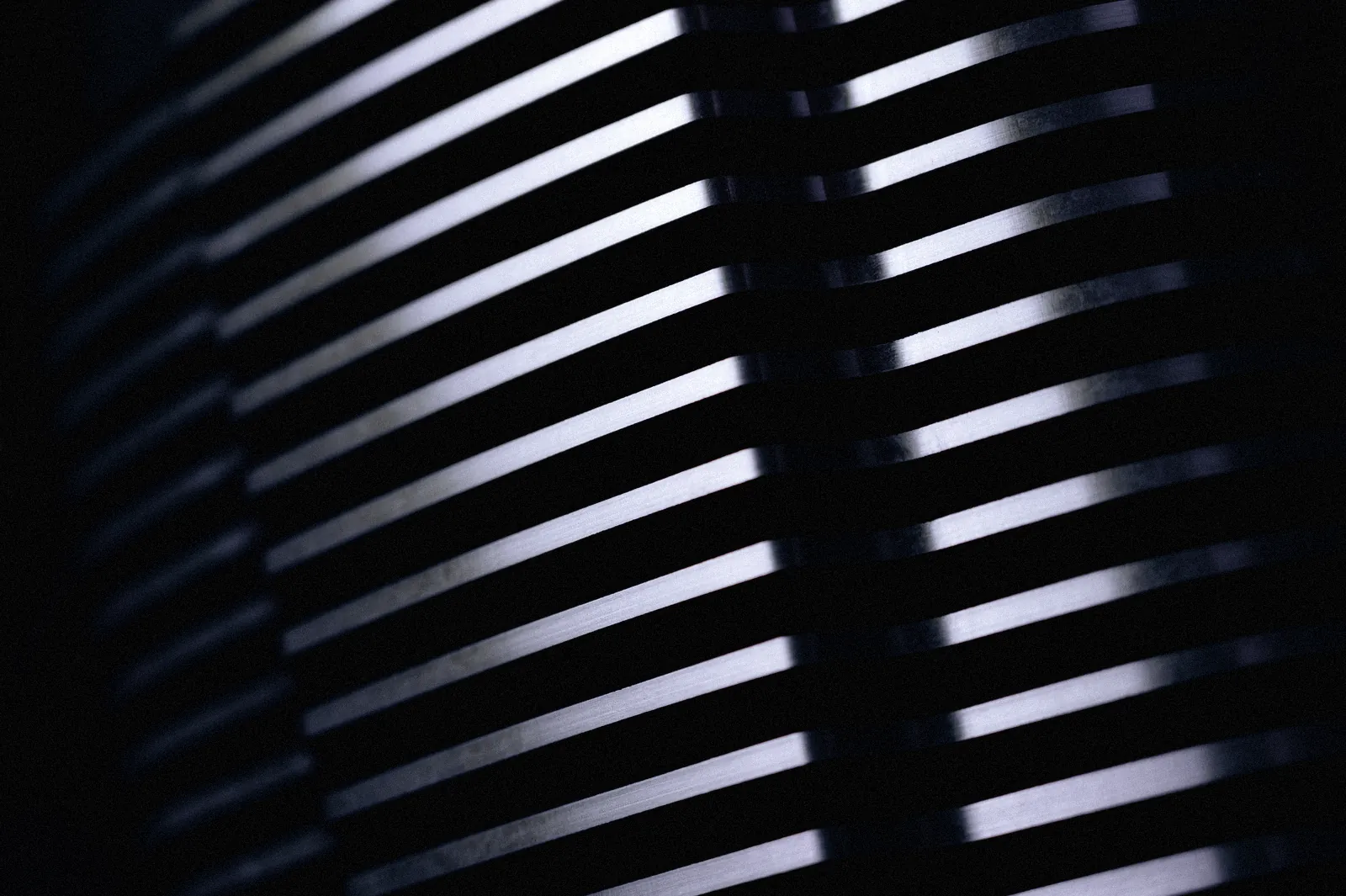 Heatsink fins in raking light, a field of bright stripes.