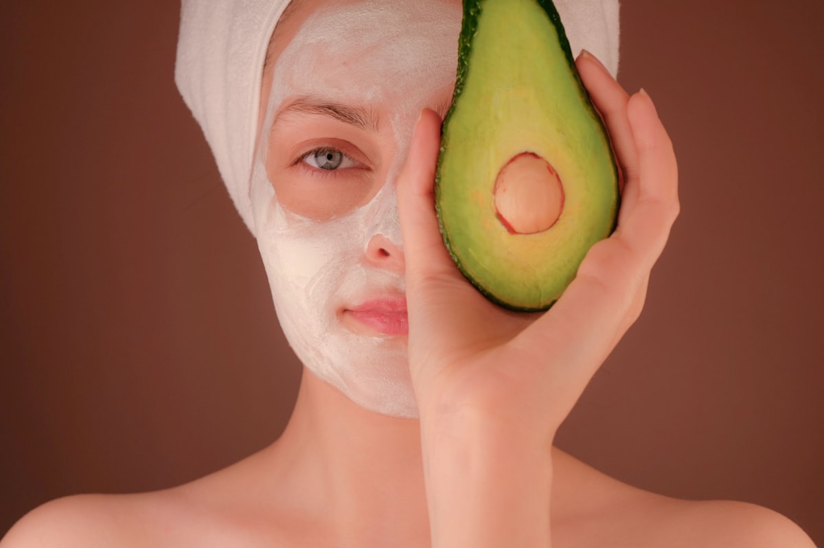 Creamy face mask texture beside botanical leaves.