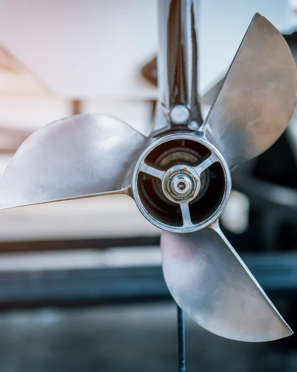 A cast bronze propeller in low sun, its blades polished bright