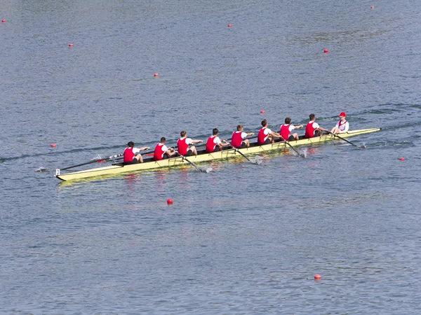 Two eights rowing on a flat, mirror-still lake