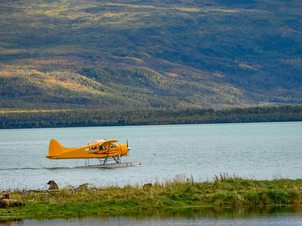 A float plane at rest on a lake below a hillside