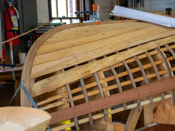 The ribs of a new hull on its bucks inside the shed